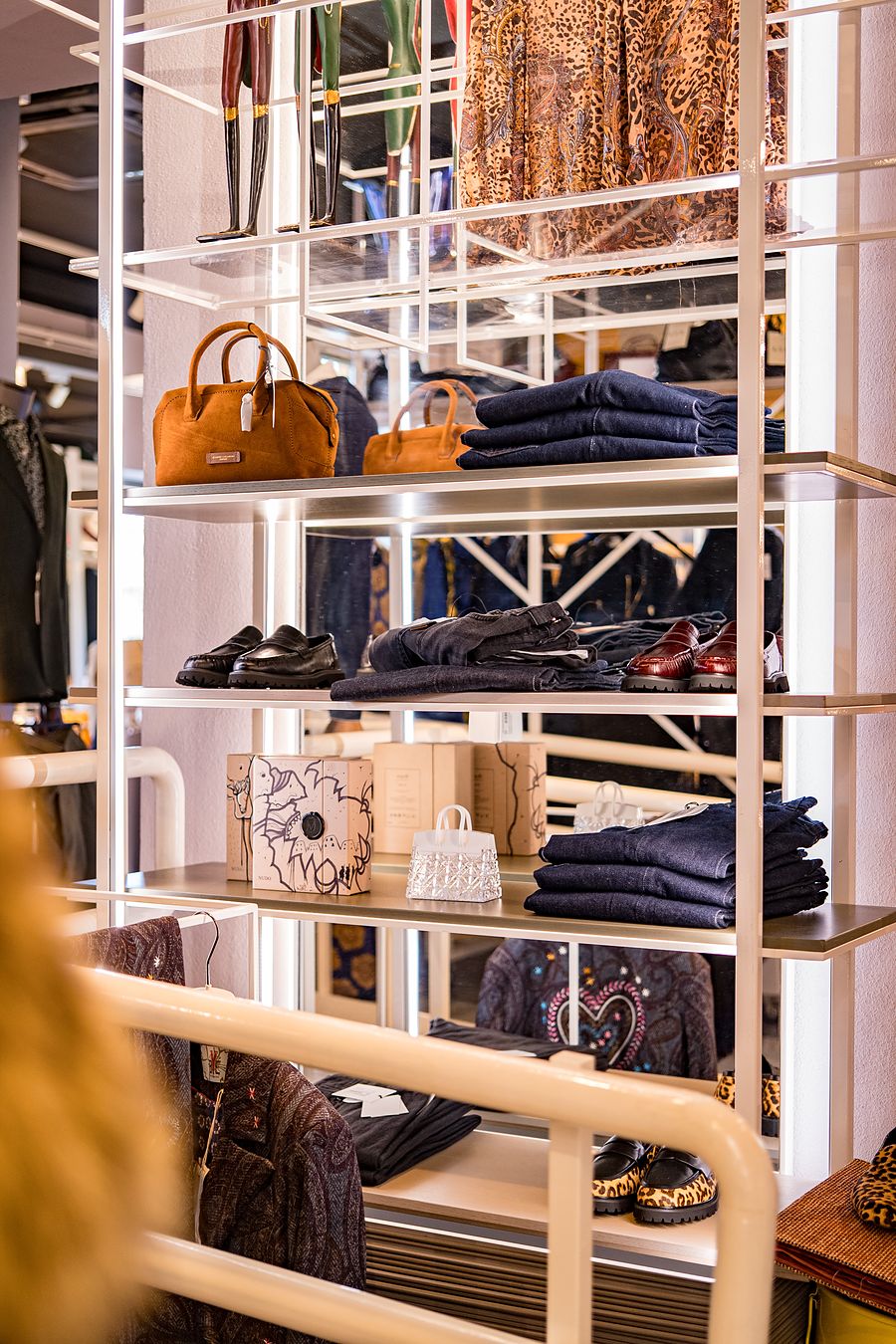 Scaffalatura bianca con borse e jeans